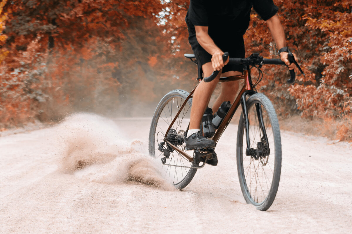 Moški vozi gravel kolo po makedamu.
