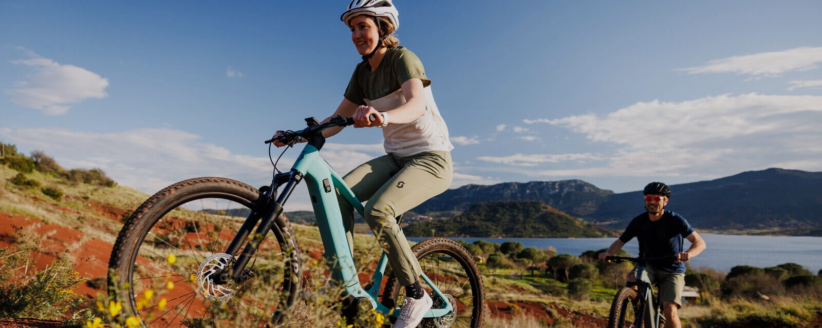 Ženska vozi električno prednje vzmeteno gorko kolo med hribi.